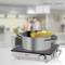 A pot of boiling spaghetti sits on an electric hob in a modern kitchen with a blurred background.