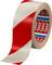 Warning tape, red and white striped, rolled up. Used for marking or cordoning off areas. Brand name 'tesa' visible inside.