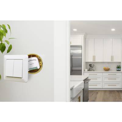 Light switch overlooking a modern kitchen; the switch is open to reveal a smart home module.