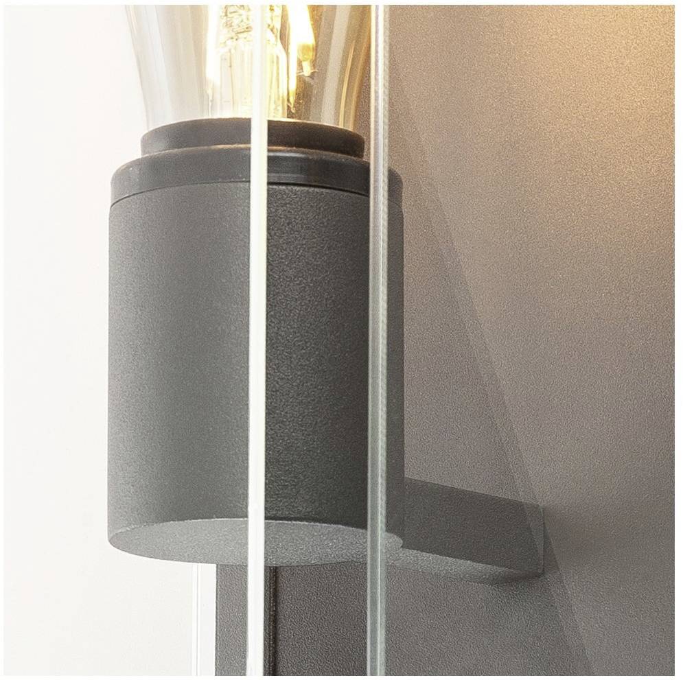 A black wall light in a contemporary design with a clear light bulb that provides soft, ambient lighting.