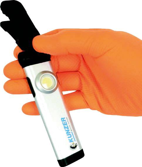 'A hand wearing an orange glove is holding a digital device with the label KUNZER, apparently a tool or measuring instrument.'