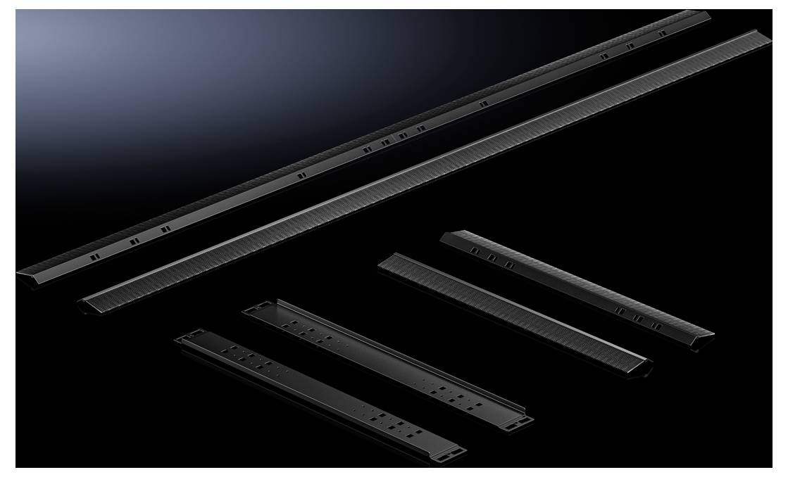 Several black metal strips of varying lengths and shapes are arranged on a dark background.