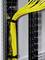 Yellow network cables are organised in a server rack and run vertically along the black structure.