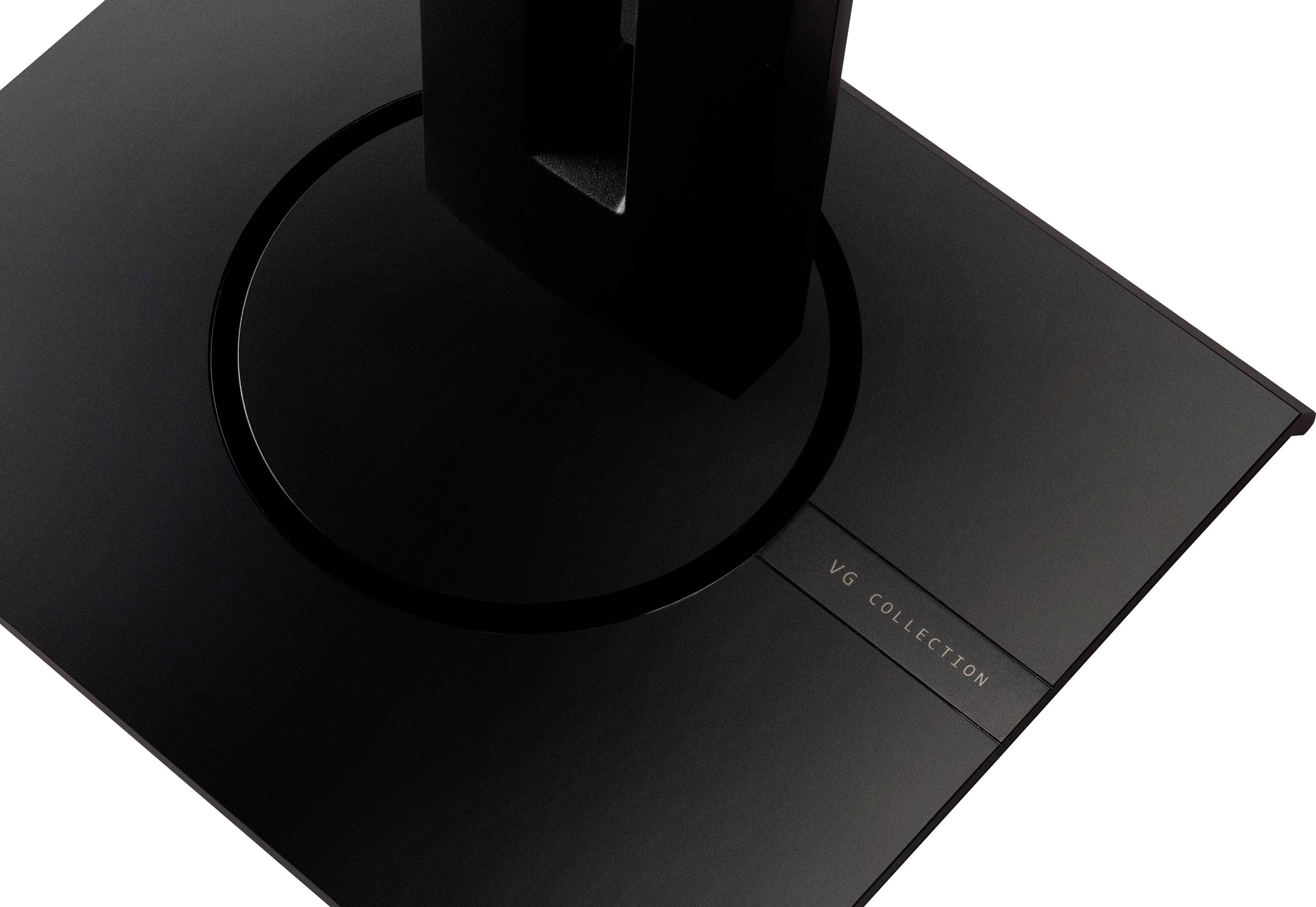 A black monitor stand with a rectangular base, with the text 'VG COLLECTION' visible on a plaque.