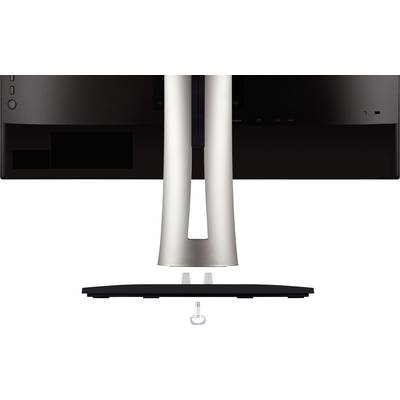A computer monitor is shown from behind, mounted on a stand. A screw lies underneath to ensure stability.