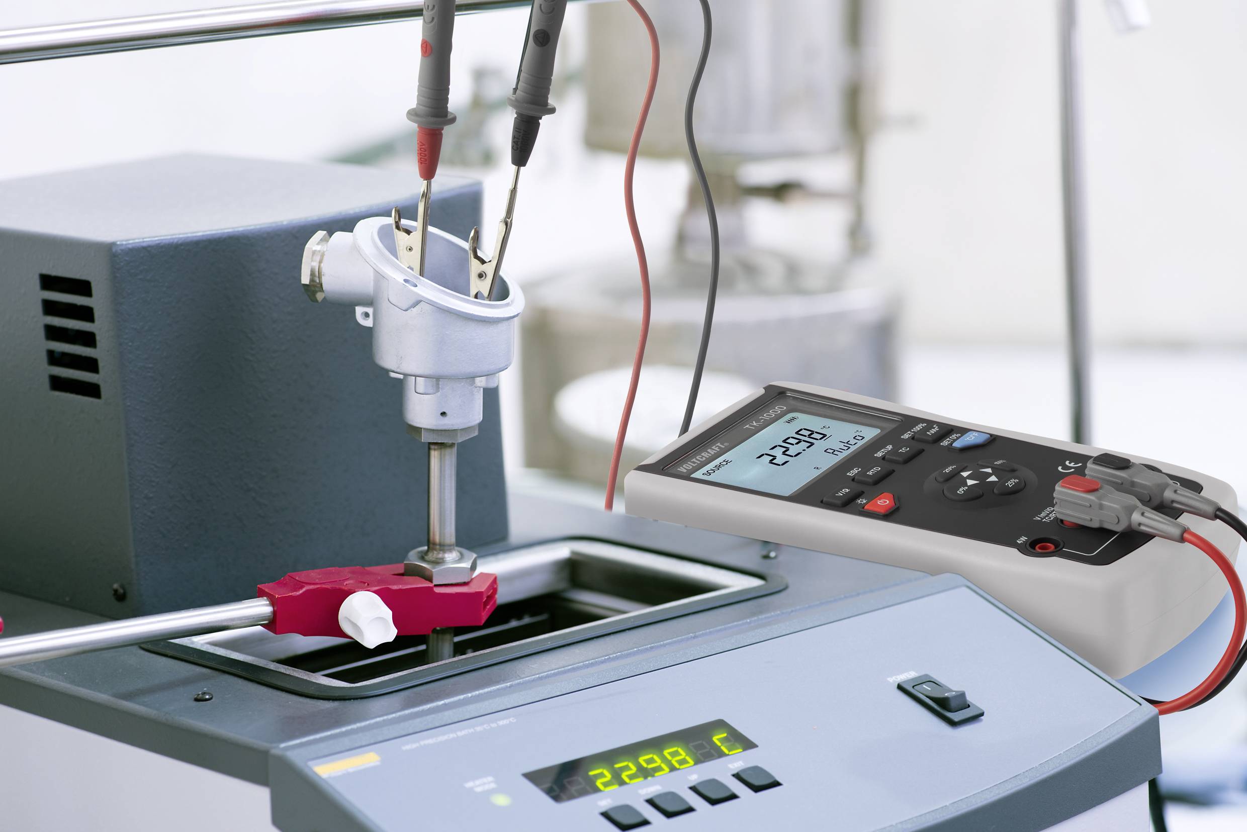 Digital display of a thermometer in a laboratory environment. A sensor measures the temperature at 22.98 °C in a liquid.