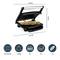 A table grill for paninis is open, with a sandwich inside. Below, symbols show size 34 x 24 cm, weight 2.6 kg, and capacity for 4 sandwiches, 2 steaks, 3 fish pieces.