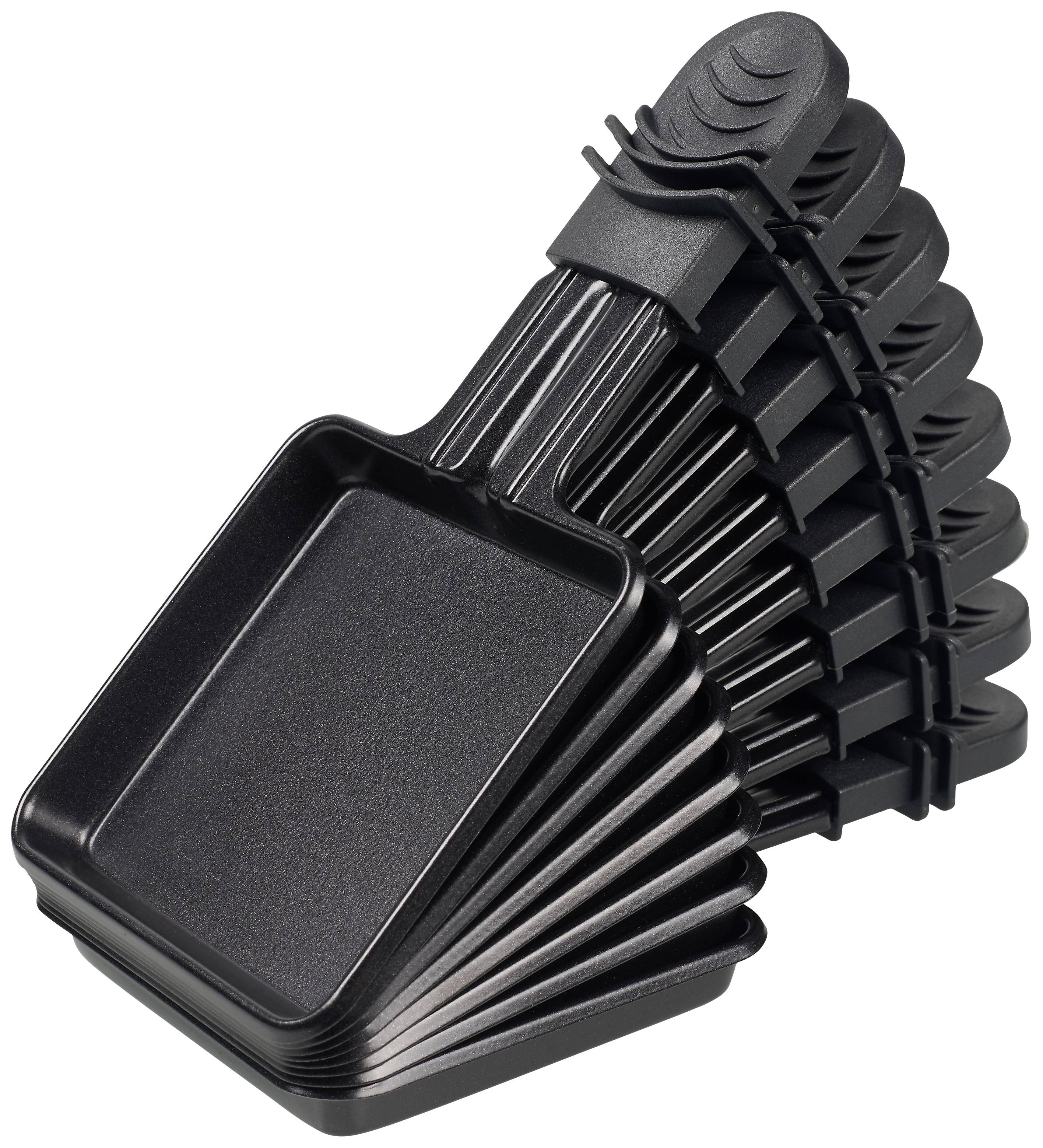 A stack of seven black raclette dishes stacked on top of each other, with black handles. Designed for cooking at the table.
