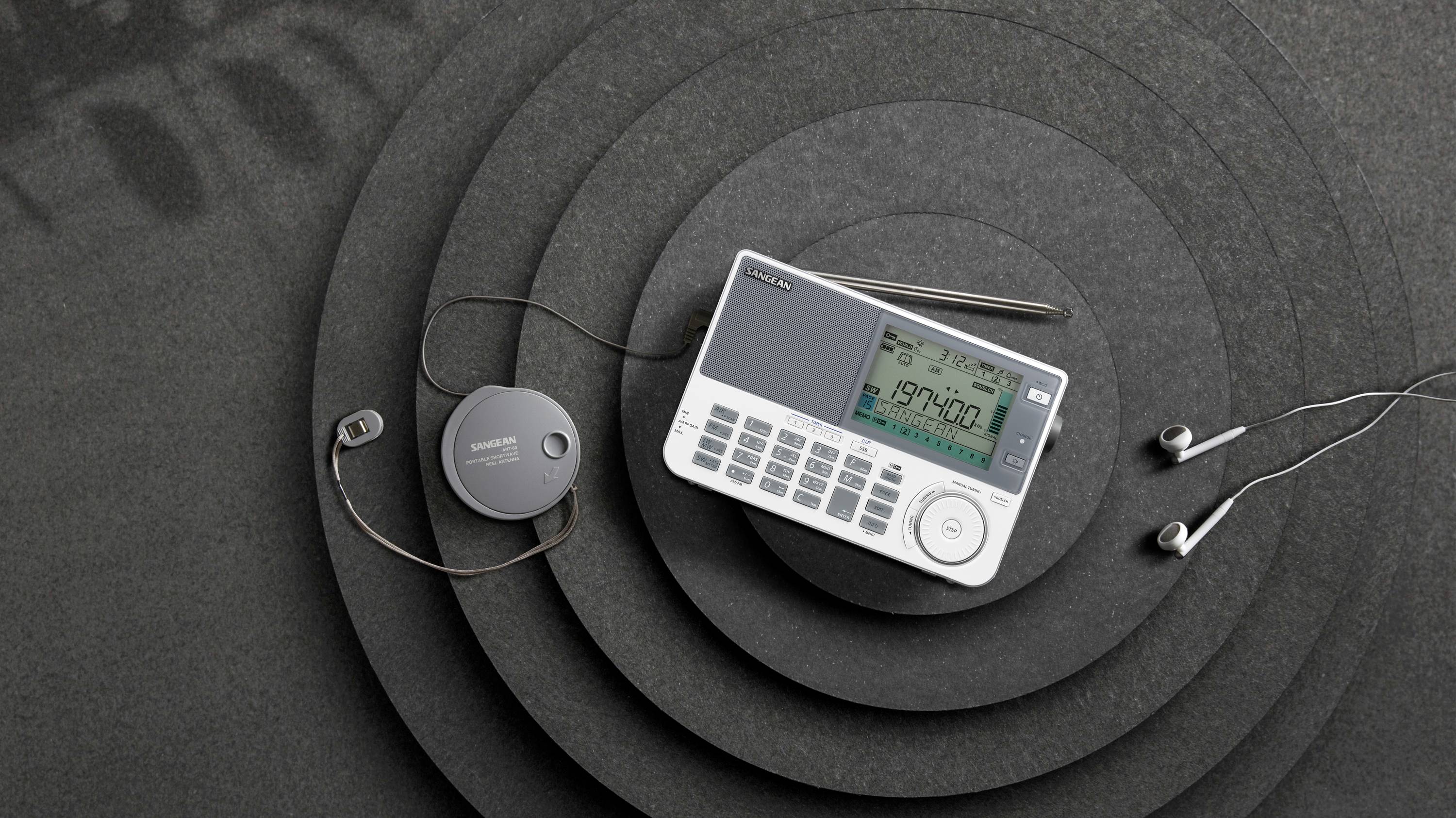 Portable CD player with display and headphones on a black background. Retro design with buttons and volume control.
