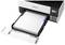 An Epson printer with an open paper cassette, showing colour ink tanks on the right side, ready to print.