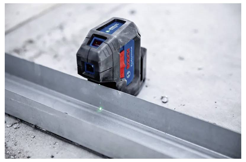 A laser level projects a green beam across a metal surface, used for precise measurements in construction and alignment tasks.