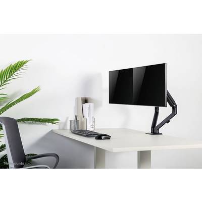Modern desk with a monitor on a movable arm, keyboard and mouse. A potted plant and an office chair to the left.