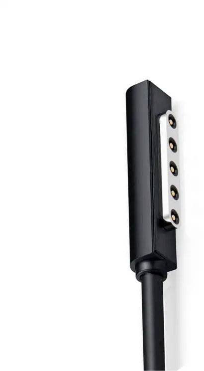 A black magnetic charging device with a square head and five gold-coloured contacts on a white background.