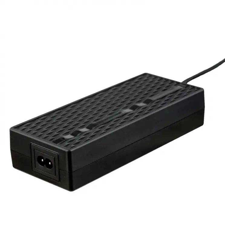 A black power supply with ventilation slots on the top and a power cable, similar to a laptop charger.