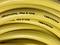 'Yellow flexible hoses with the inscription "Soft & Flex Technology" and "Primabel" are coiled over each other multiple times.'