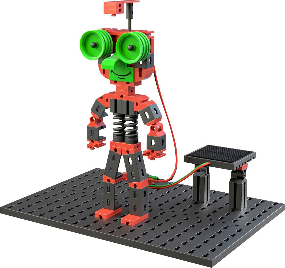 A small robot made of red and black components stands on a perforated plate. The robot has large, green eyes and a cable is connected.