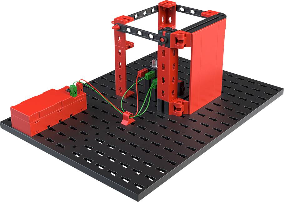 A square red structure on a perforated plate with a connected red battery via green and red cables.