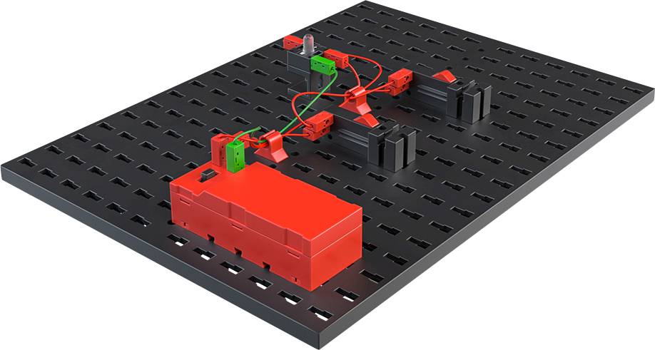Black circuit board with red and green components in a technical configuration, connected by cables, demonstrating electronics.