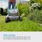 A person is mowing a lawn with a lawnmower in a garden. Text in the image: 'High Performance. The brushless motor is characterised by its high performance and impressive efficiency.'