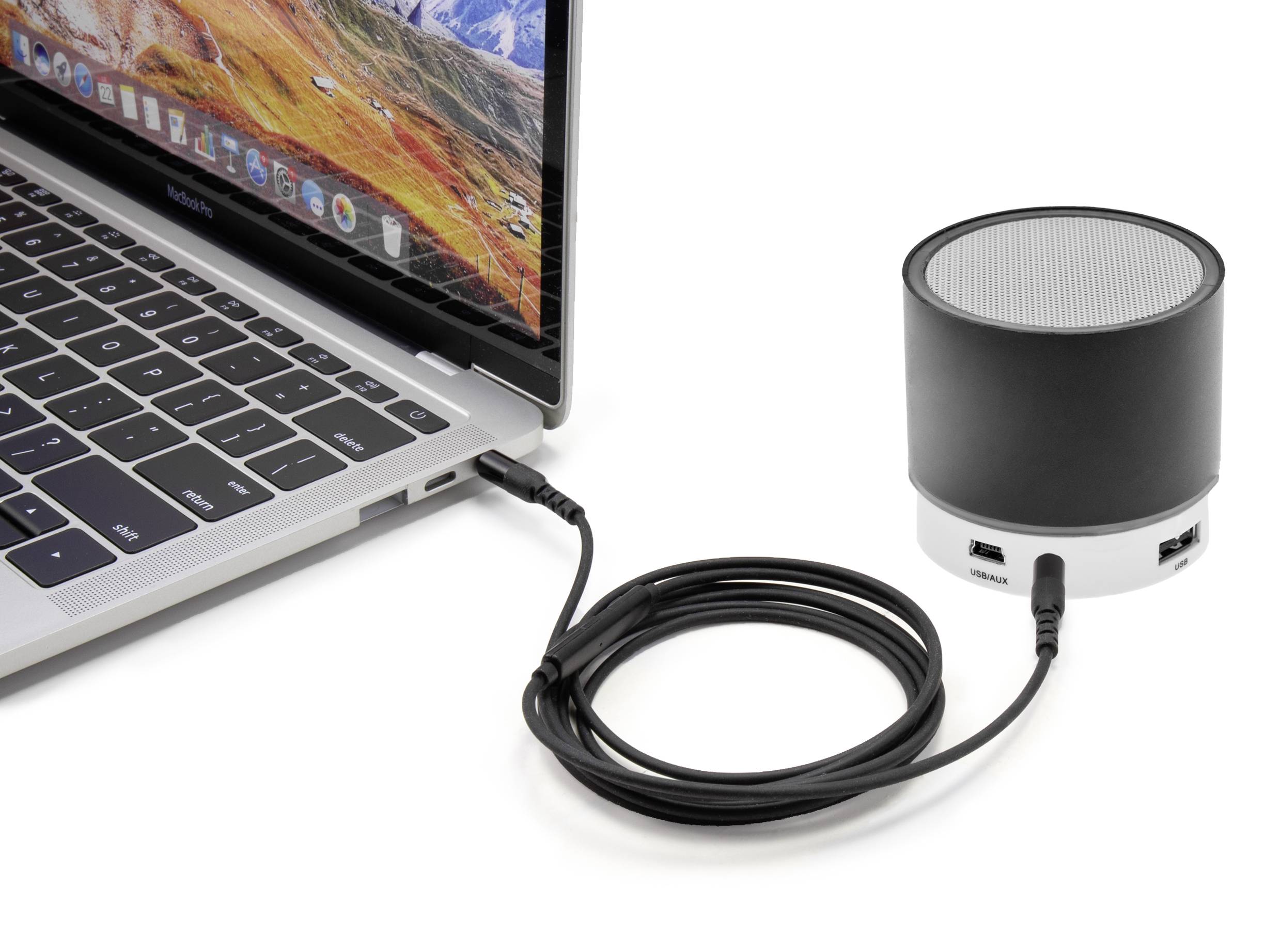 External hard drive connected to a laptop via a USB cable. A colourful landscape is displayed on the laptop screen.