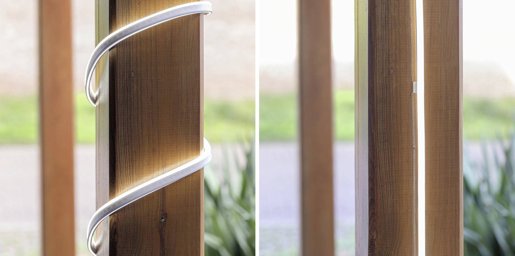 Wooden posts outdoors, left with wrapped LED light strip, right without, against a blurred background. Lighting contrast.