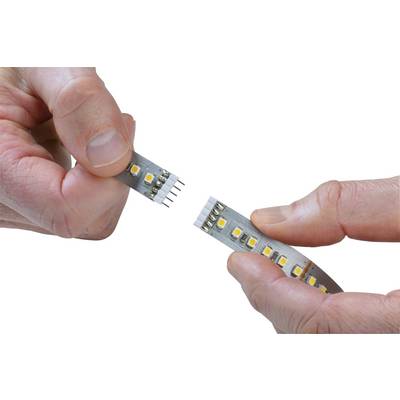 Two hands are holding separate parts of an LED strip with connectors, ready to be joined together.