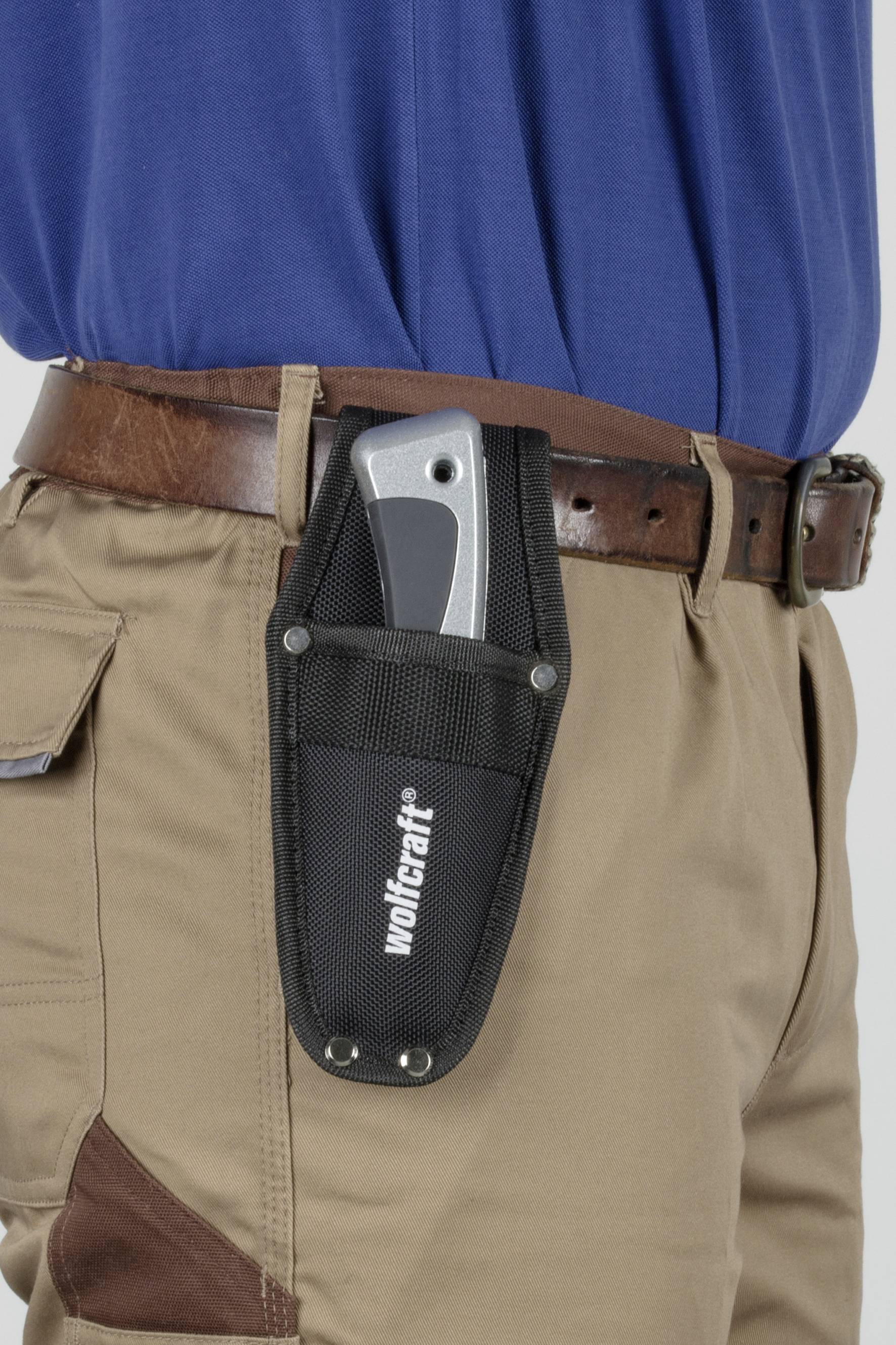 A person is wearing brown trousers with a black holster on their belt. A silver-coloured tool is nestled in the holster.