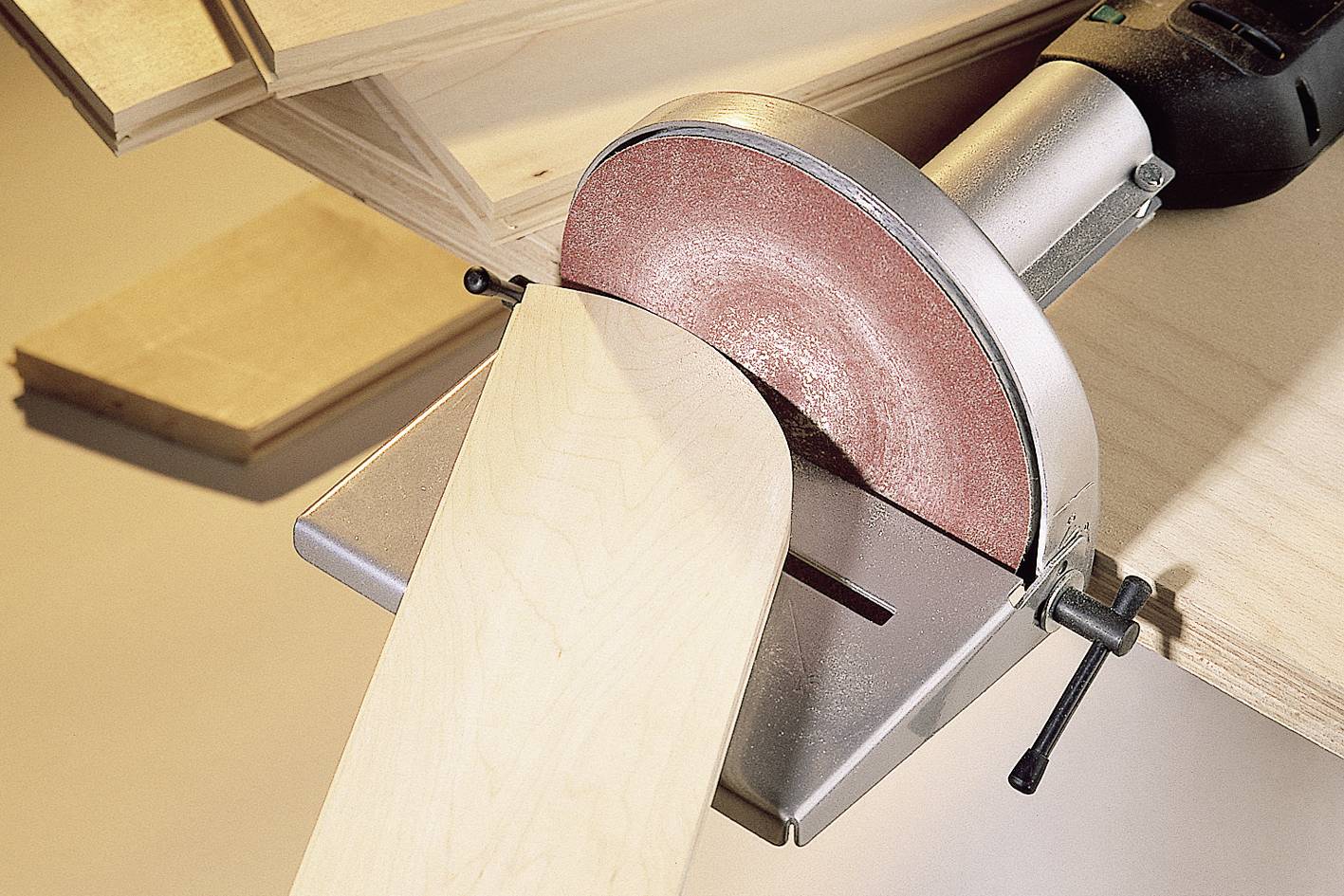A sanding machine is working on a wooden board. Surrounding boards suggest a workshop environment.