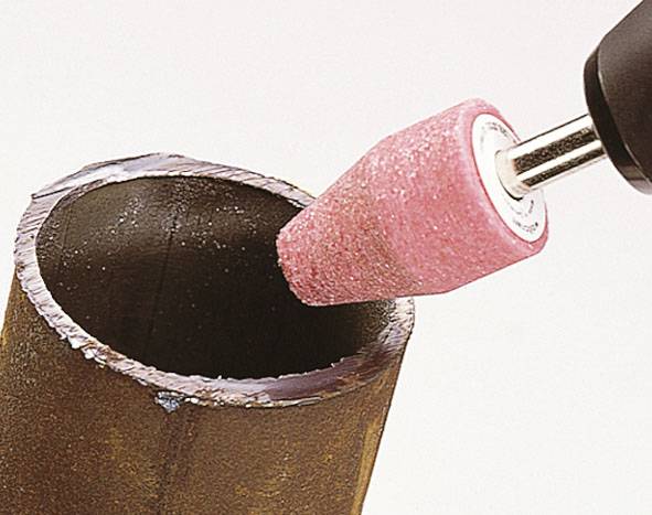 Close-up of a brown tube being polished internally with a rotating grinding attachment.