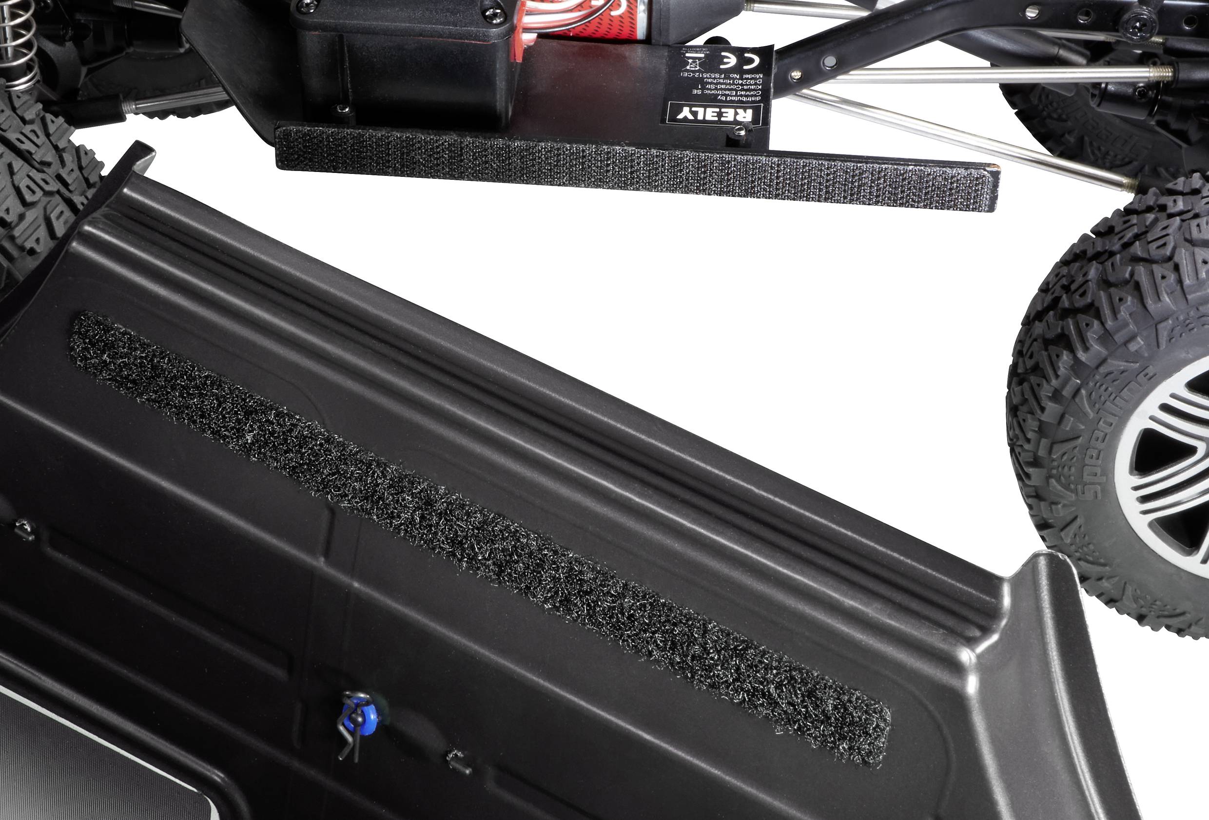 Remote-controlled car with chunky rubber tyres, view from underneath showing robust casing and battery housing.