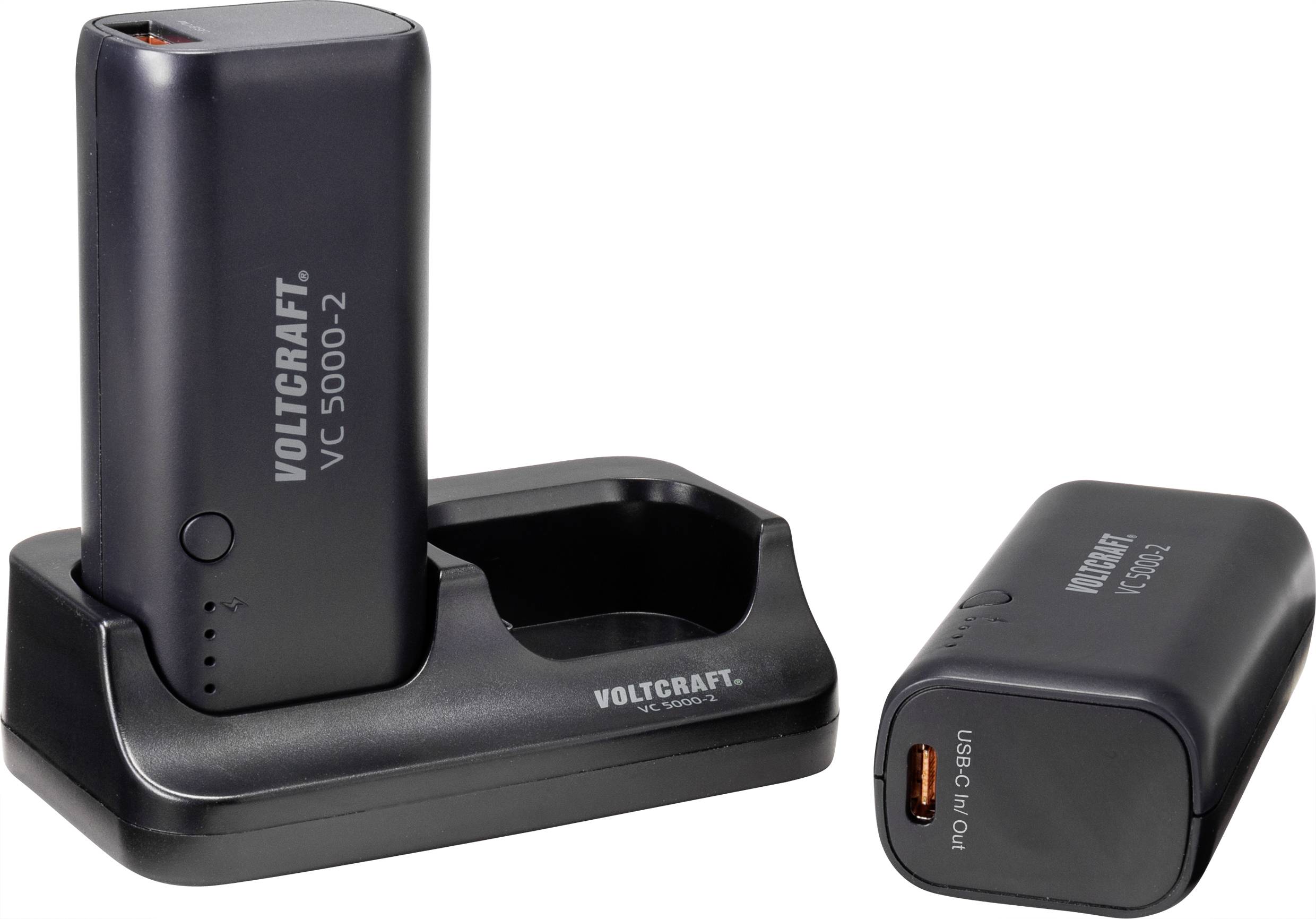 Two black Voltcraft chargers, model VC 5000-2. One is standing upright in the charging station, the other lying beside it.