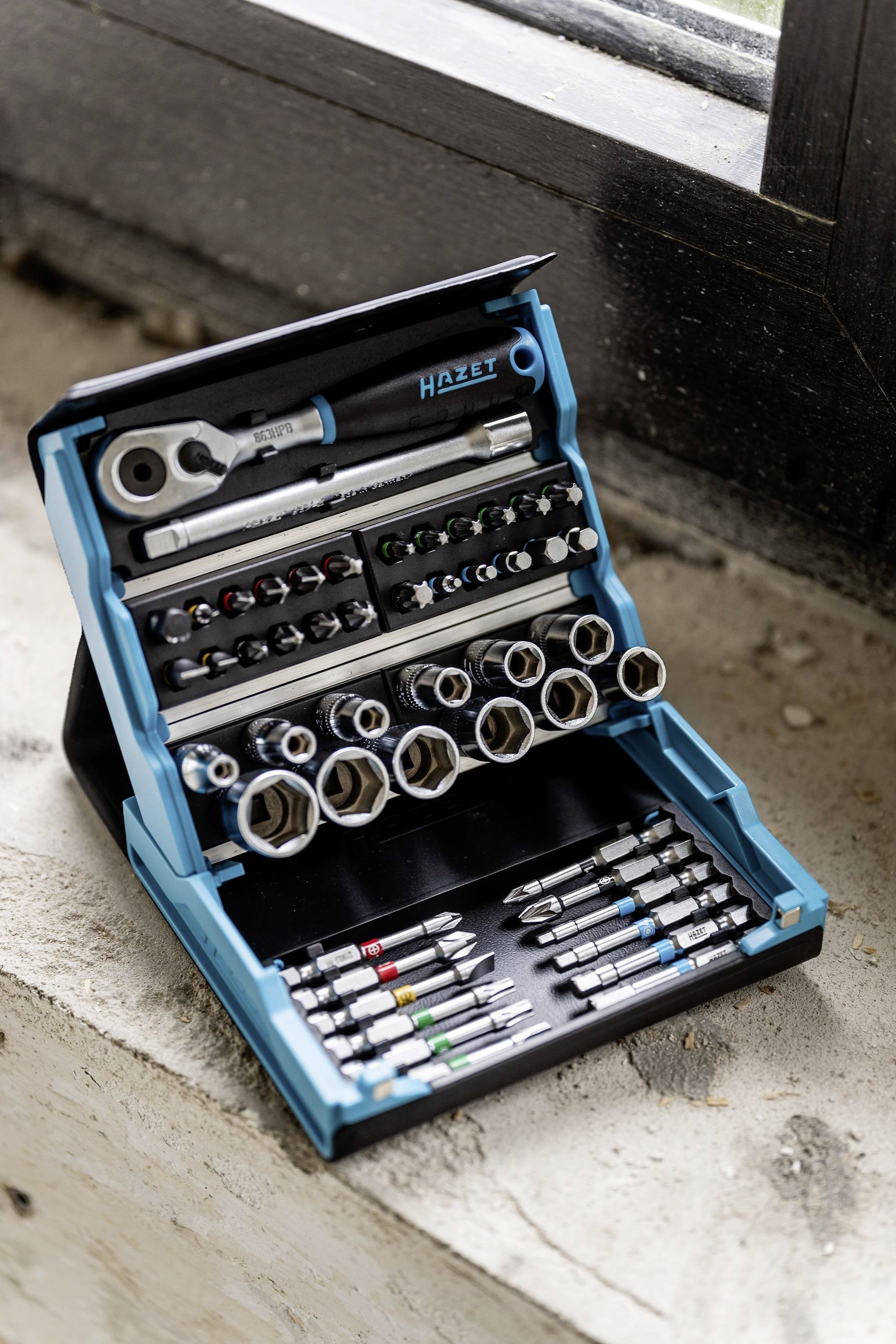 An open tool set with various spanners, sockets and bits in a blue and black case.