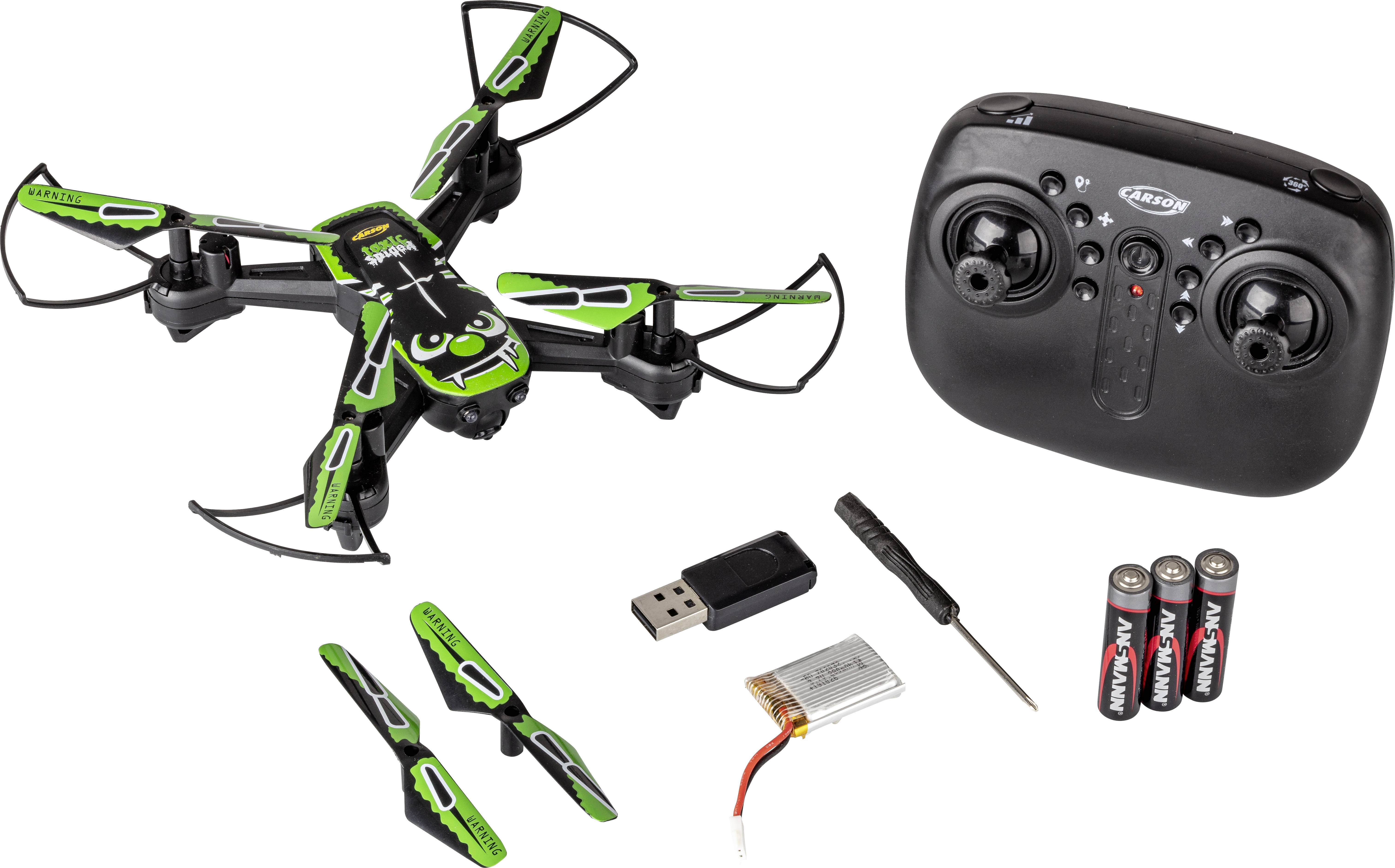 Quadcopter drone with green and black design, remote control, spare parts, batteries, and charging accessories pictured.