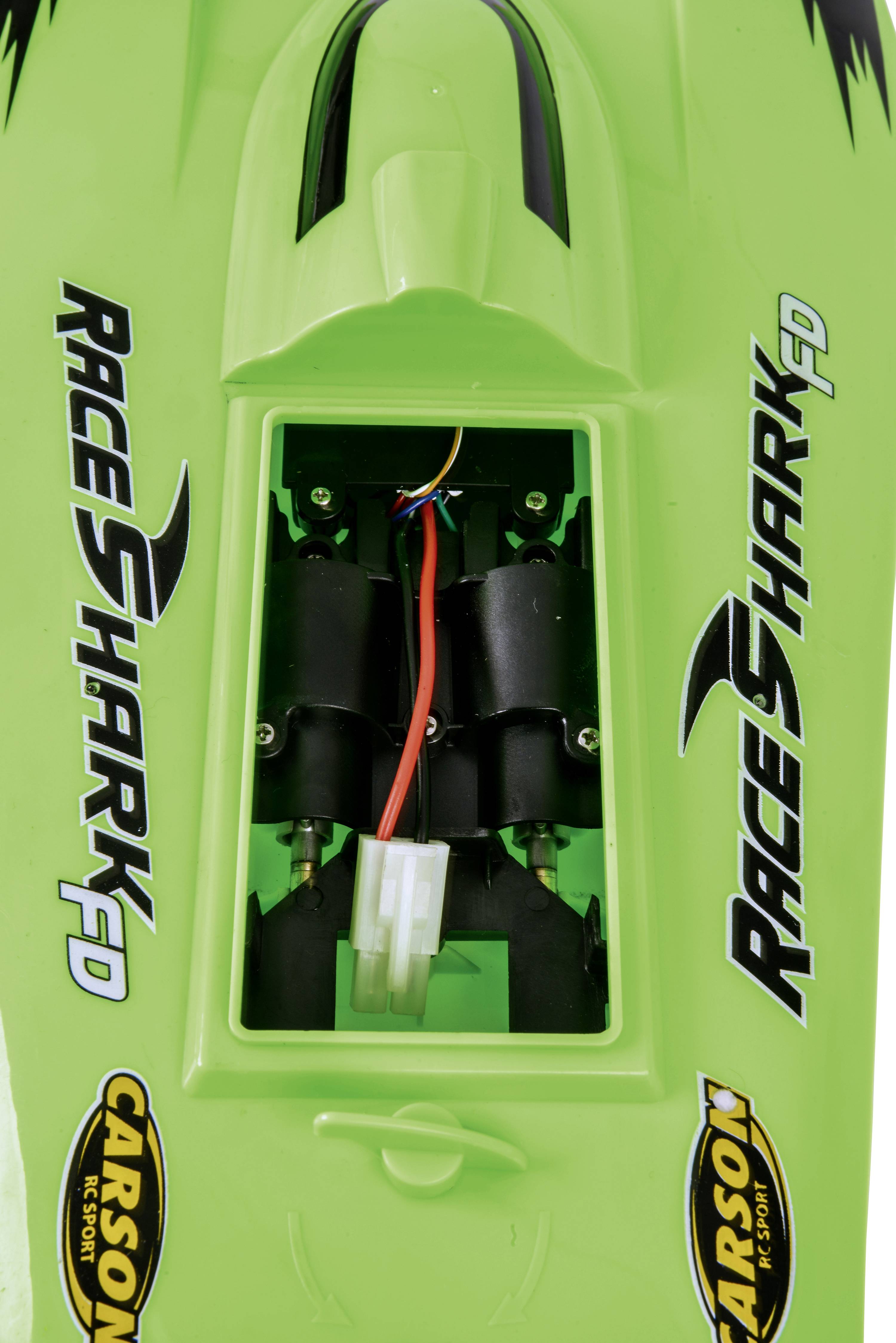 Green model boat with the inscription 'Race Shark FD'. Shows the interior with electrical components and a Carson logo on the sides.