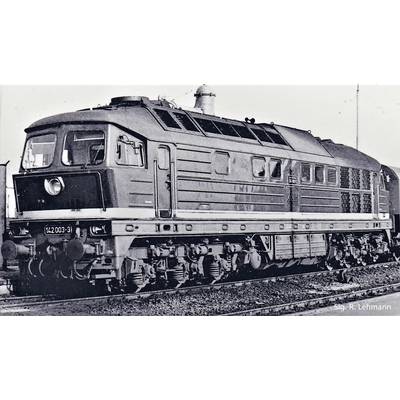 An older railway locomotive on a track. The black and white image shows the side and front view of the vehicle.