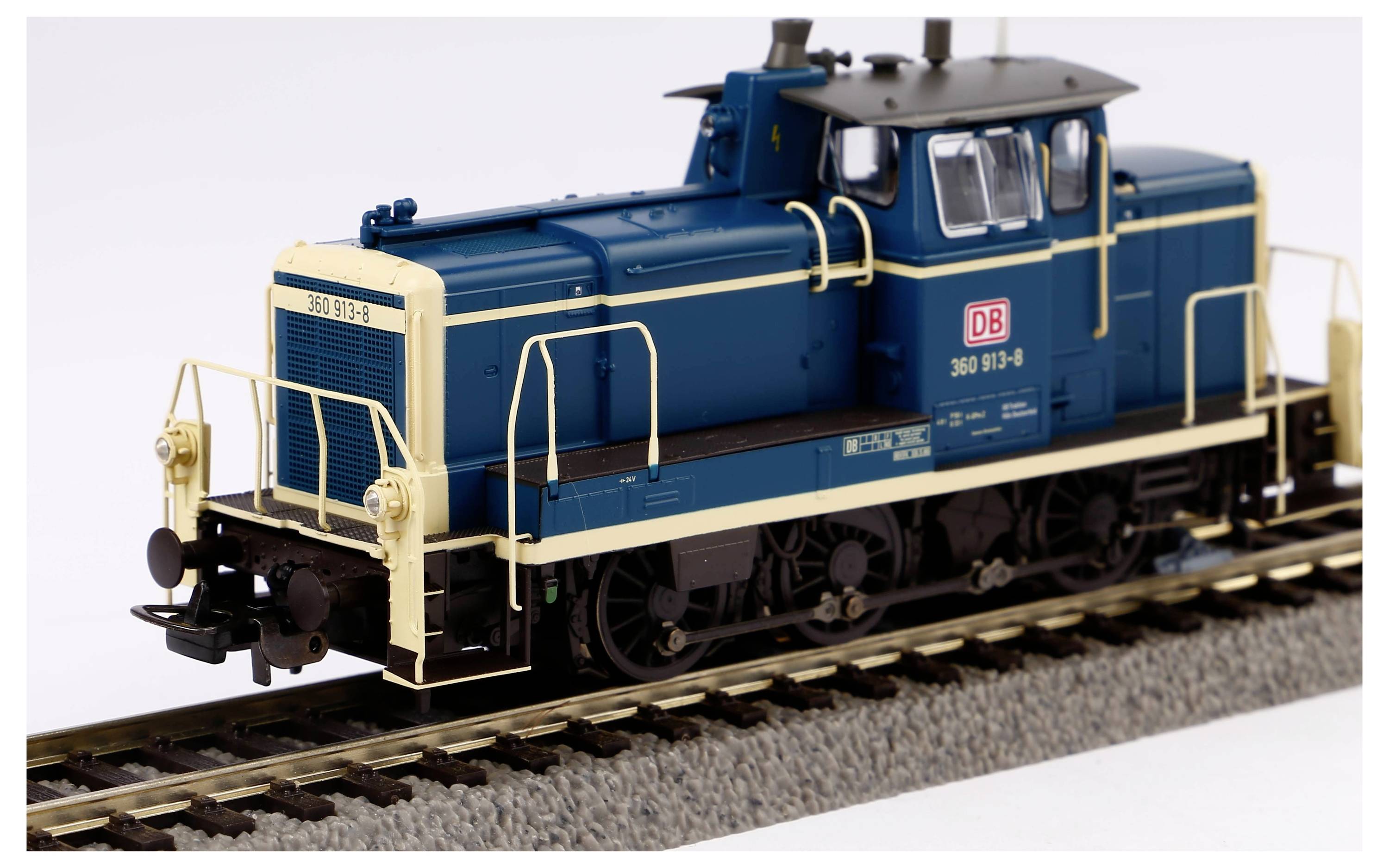 Model railway locomotive in blue and cream of Deutsche Bahn standing on tracks. Detailed representation with prominent DB logo.