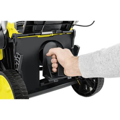 A hand grasps the handle on the back of a yellow lawnmower.