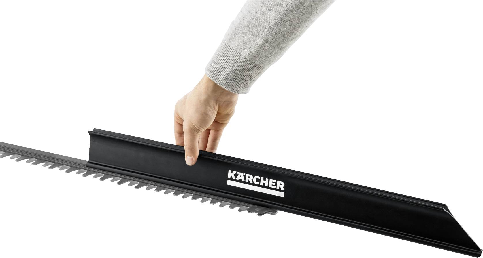 A hand is placing a black cover with the 'Kärcher' logo over the blades of a hedge trimmer, apparently for protection or storage purposes.