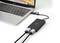 A laptop is connected to a black adapter that connects two cables. The adapter facilitates the connection of external devices.