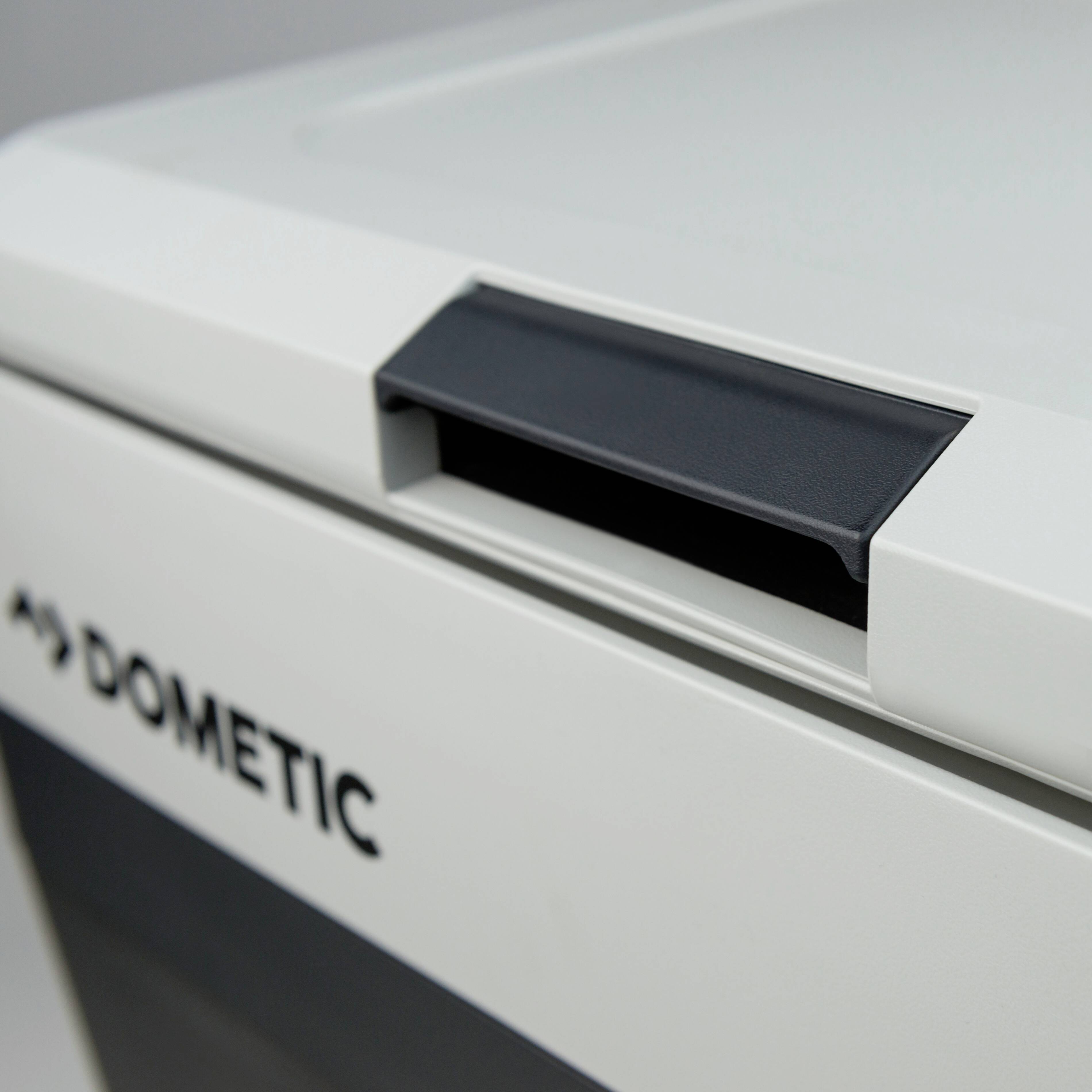A section of a Dometic portable refrigerator, featuring a black handle at the top and the brand logo on the front.