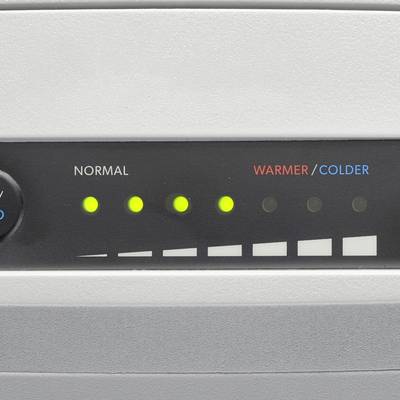 Close-up of an air conditioning control panel with a lit display for 'NORMAL' and a scale for 'WARMER/COLDER'.