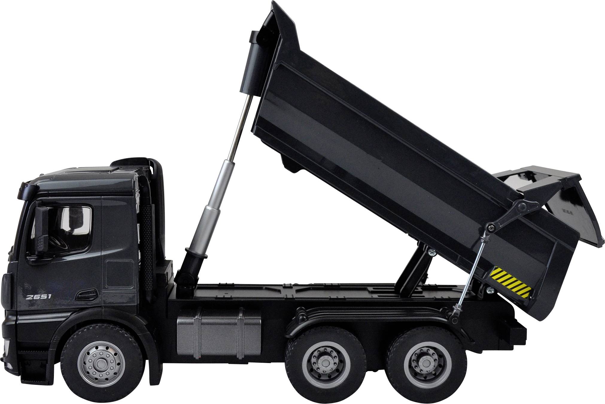 Toy tipper truck made of black plastic, shown from the side. The load bed is raised, demonstrating the function of a real lorry.