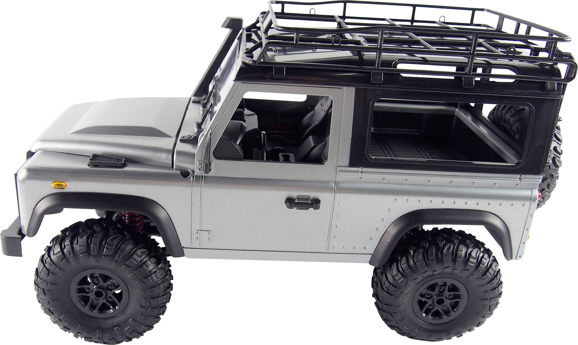 Silver toy off-road vehicle with large black tyres and a roof rack, side view.