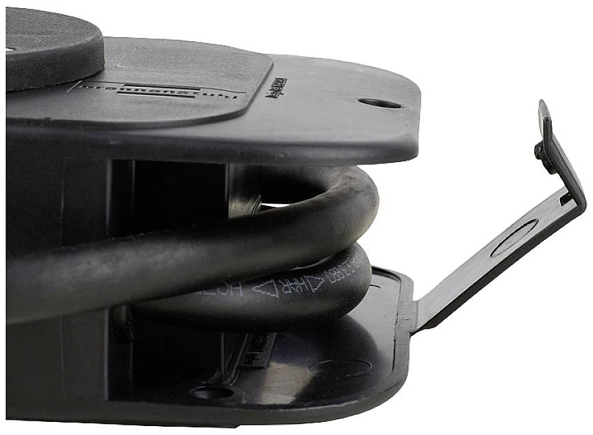 A black cable is wound around a round, flat plastic casing. A plastic flap is partially open.