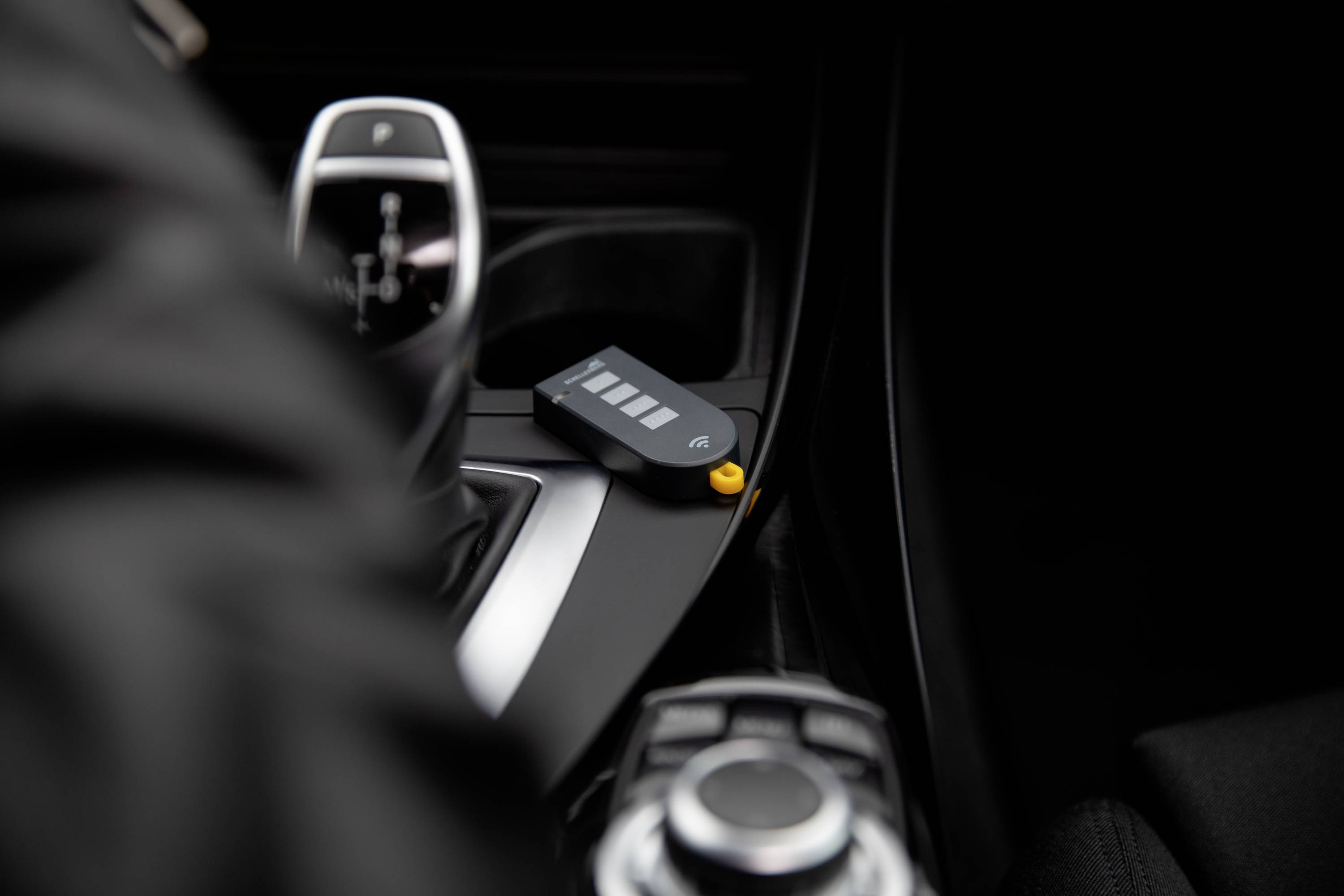 A close-up of a car key resting on the centre console of a vehicle.