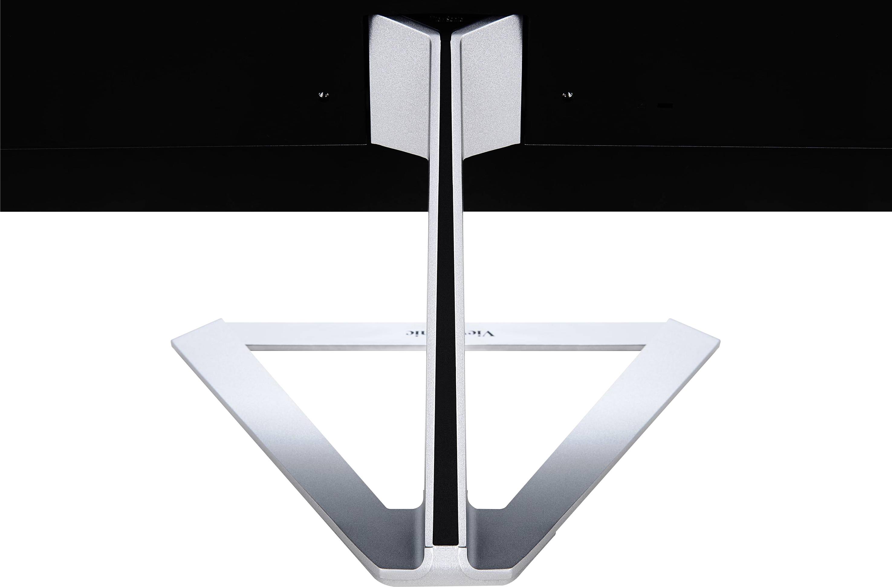 A silver monitor stand with a Y-shaped design is viewed from underneath, attached to a black screen.