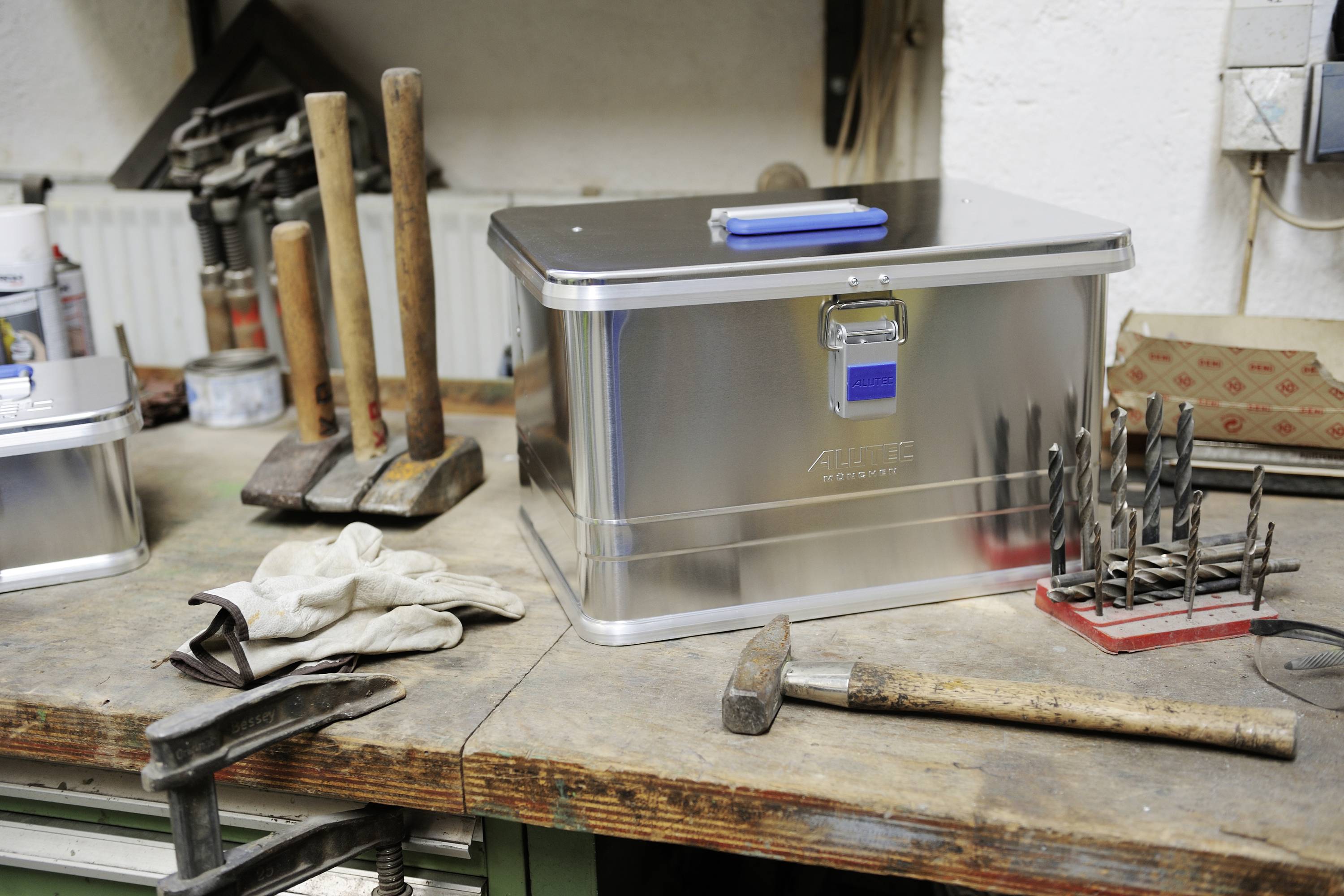 Workbench with metal toolboxes, hammers and drills. Tools neatly arranged for efficient work organisation.
