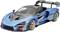 A blue, sporty racing car with an aerodynamic design and large rear spoiler, parked against a white background.