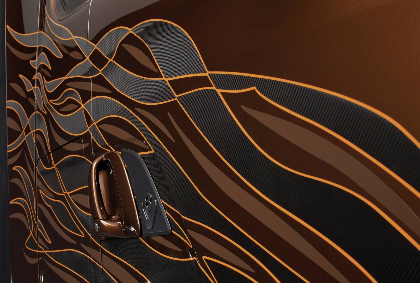 Close-up of a car door with brown and orange wavy lines as a design element, focusing on details and colour contrast.