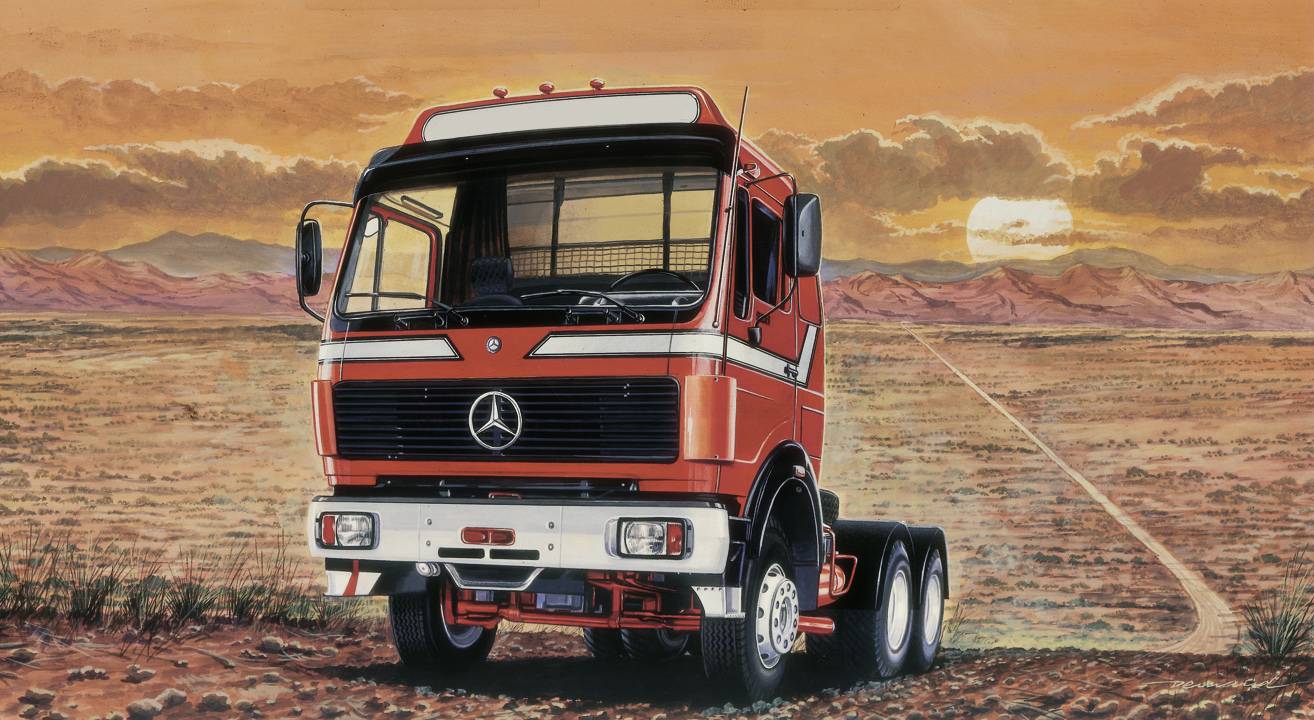 A red lorry stands on a desert road, with sunset in the background. The sky is orange and cloudy, the landscape barren.